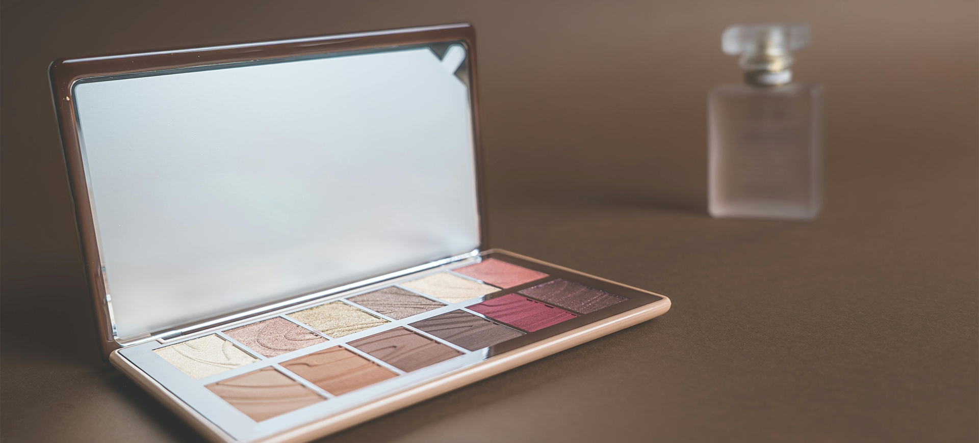 Makeup palette with a mirror on a brown background